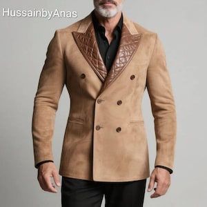 Może przedstawiać: Beżowa dwurzędowa marynarka z brązowym, pikowanym skórzanym kołnierzem. Marynarka ma cztery guziki i dwie przednie kieszenie. Rękawy mają czarne wykończenia. Tekst "HussainbyAnas" znajduje się w lewym górnym rogu.