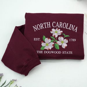 Embroidered Dogwood flower on maroon sweatshirt
