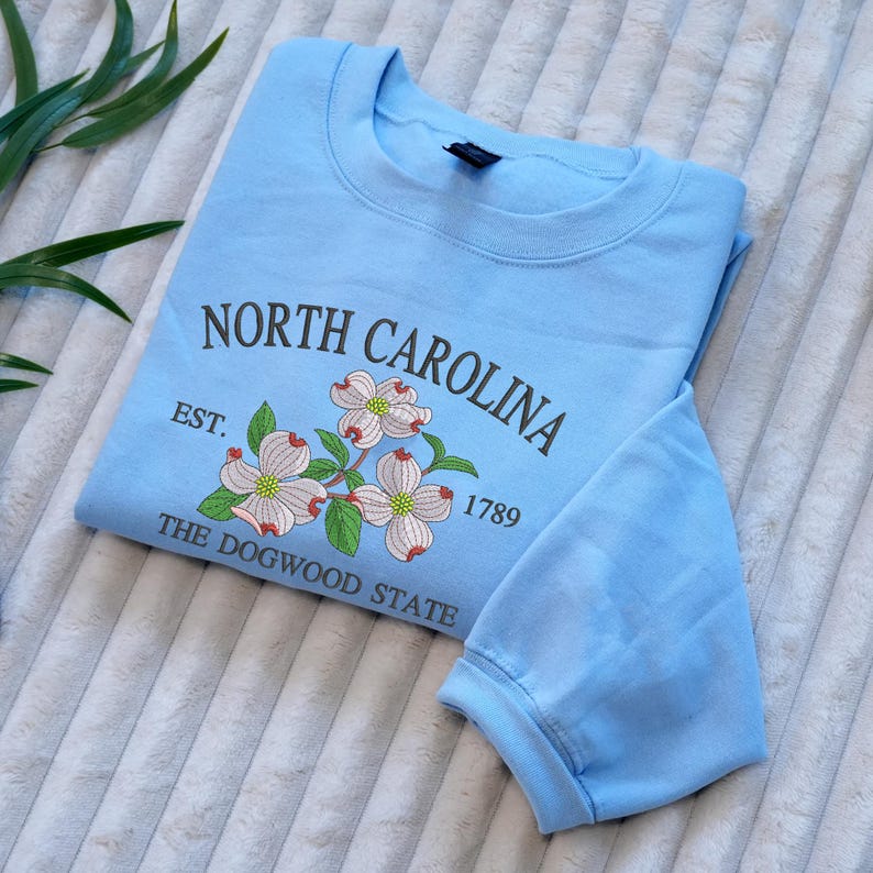 Embroidered Dogwood flower on light blue sweatshirt