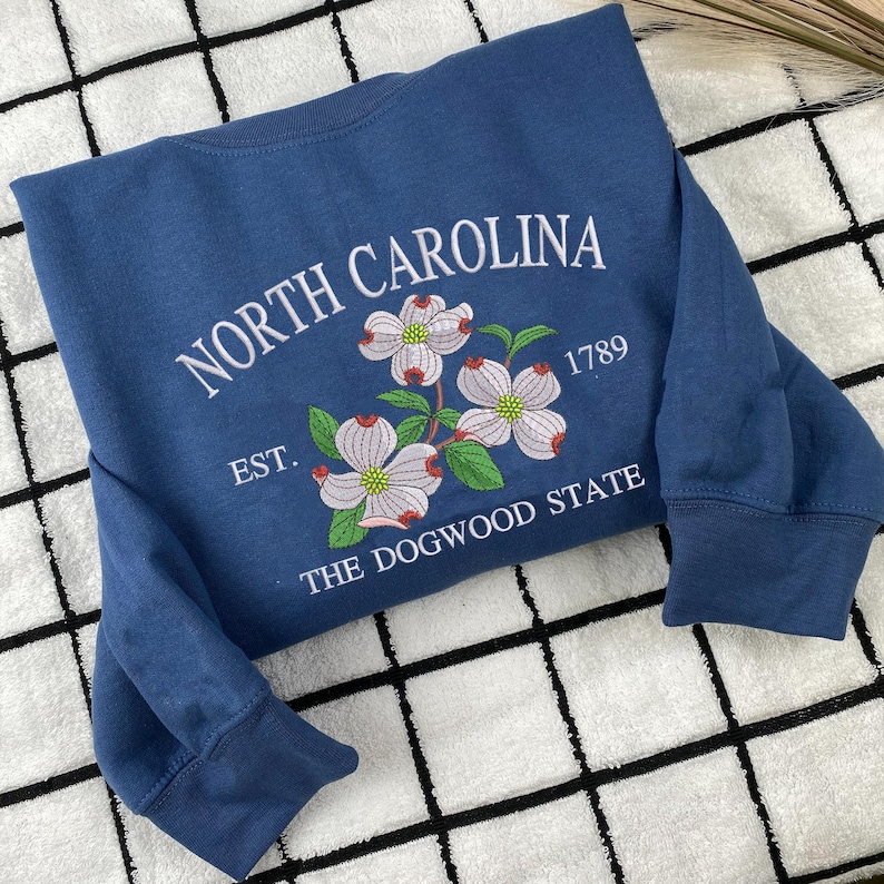 Embroidered Dogwood flower on blue sweatshirt