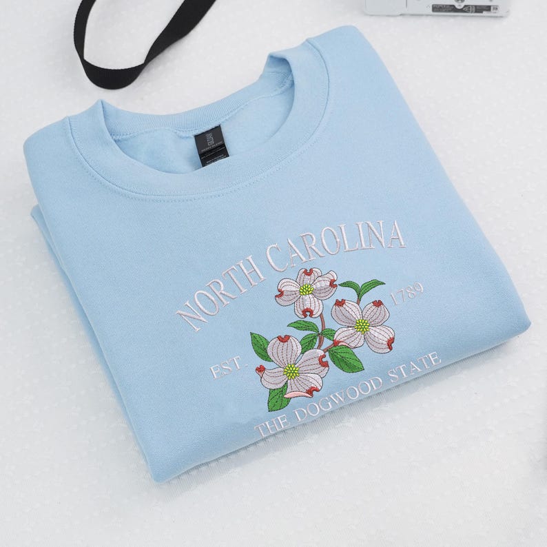 Embroidered Dogwood flower on light blue sweatshirt