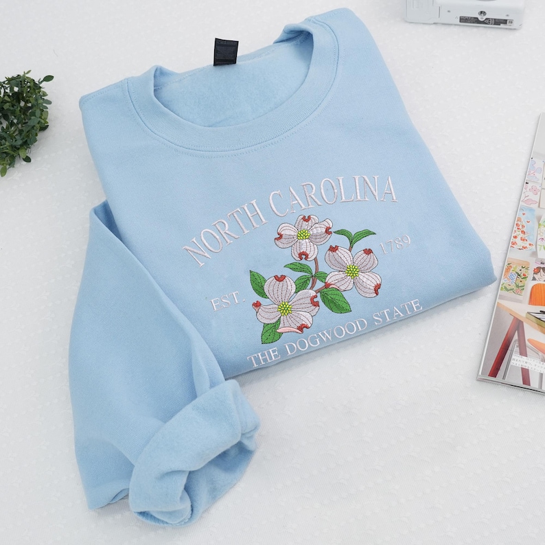 Embroidered Dogwood flower on light blue sweatshirt
