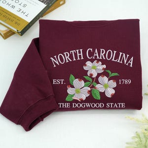 Embroidered Dogwood flower on maroon sweatshirt