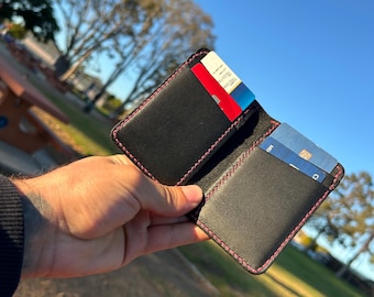 ハンドステッチの二つ折り財布。横型カードポケット。黒と赤のレザーに