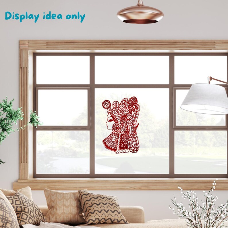 May include: A red paper cut-out of a woman in traditional Chinese opera attire is displayed on a window. The intricate design features detailed patterns and a decorative headdress. The text "Display idea only" is in the upper left corner.