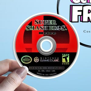 May include: A Super Smash Bros. Melee video game disc for the Nintendo GameCube. The disc has a red and black design with the game title and logo prominently displayed. The disc is rated "Teen" by the ESRB.