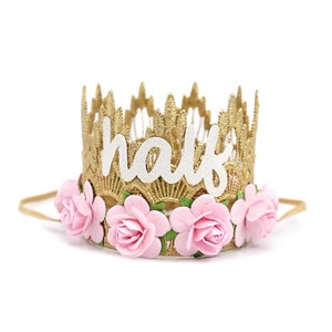 gold lace half birthday crown with light pink flowers and white sparkly "half" in cursive letters.