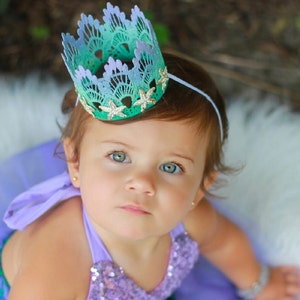 Mermaid first birthday crown with aqua lace, gold glitter starfish, and a glittery “one” topper. Perfect for a mermaid birthday party, Oneder the Sea theme, cake smash photoshoot, or beach baby shower. Handmade, lightweight, and customizable.