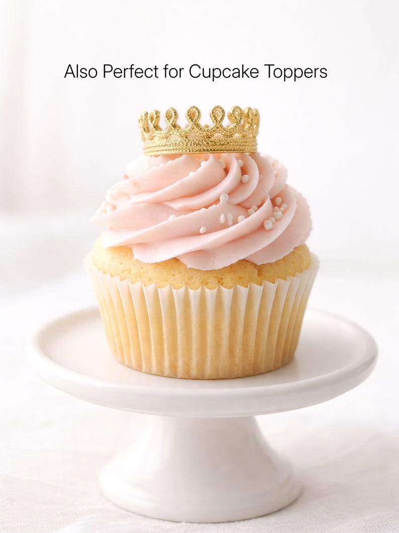 Mini gold lace crown cupcake topper on blush pink frosted cupcake with pearl sprinkles, displayed on white cake stand, tiny crown party decor, first birthday theme