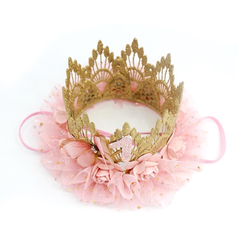 Close-up of handcrafted gold lace first birthday crown with a blush pink tutu trim, delicate butterfly accent, and floral details. Designed for baby girls celebrating their milestone with a dreamy princess or ballerina theme. LoveCrush Crowns® makes high-quality handmade crowns for special moments.