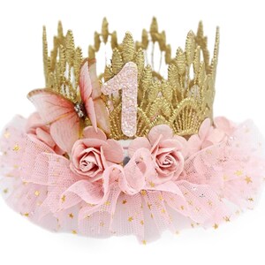 Gold lace crown with sparkly blush number 1, organza butterfly with rhinestone detail, blush pink roses, and blush pink ruffled tutu trim with gold stars. Perfect for baby girl first birthday, cake smash photoshoot, and fairy princess theme. Handmade by LoveCrush Crowns®. Can be customized in any age.