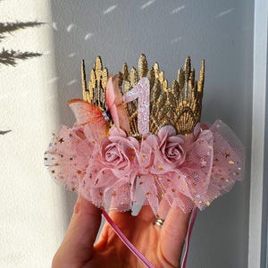 Blush pink fairy tutu crown with lace details, golden stars, and handcrafted floral embellishments. A perfect baby girl birthday headband for princess dress-up, cake smash, and first birthday celebrations. LoveCrush Crowns® specializes in unique handmade crowns made in the USA.