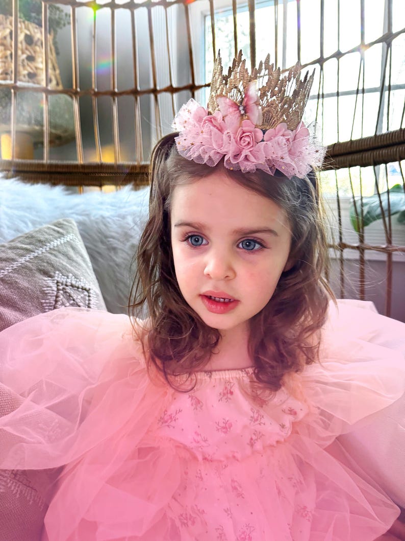 Handmade first birthday headband featuring a gold lace crown with blush pink tulle tutu trim, butterflies, and flowers. A must-have for milestone celebrations, fairy princess parties, and dress-up play. LoveCrush Crowns® is known for its elegant handcrafted crowns.