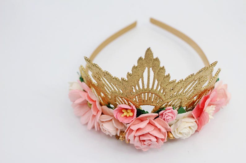 May include: Gold crown headband with pink and white felt flowers. The crown is made of a delicate lace design.