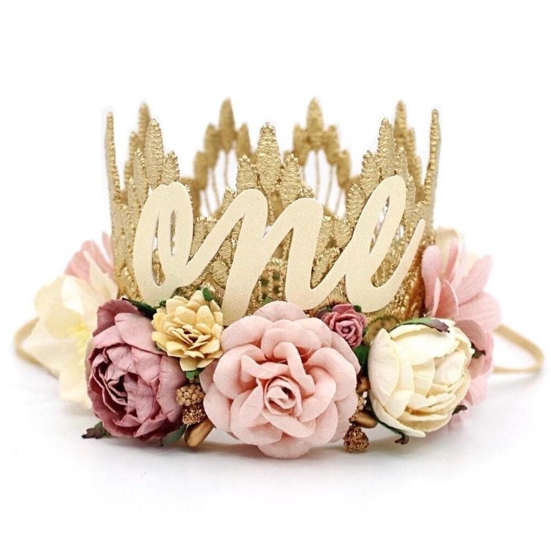 May include: Gold crown headband with a white "one" cutout and pink and cream flowers.