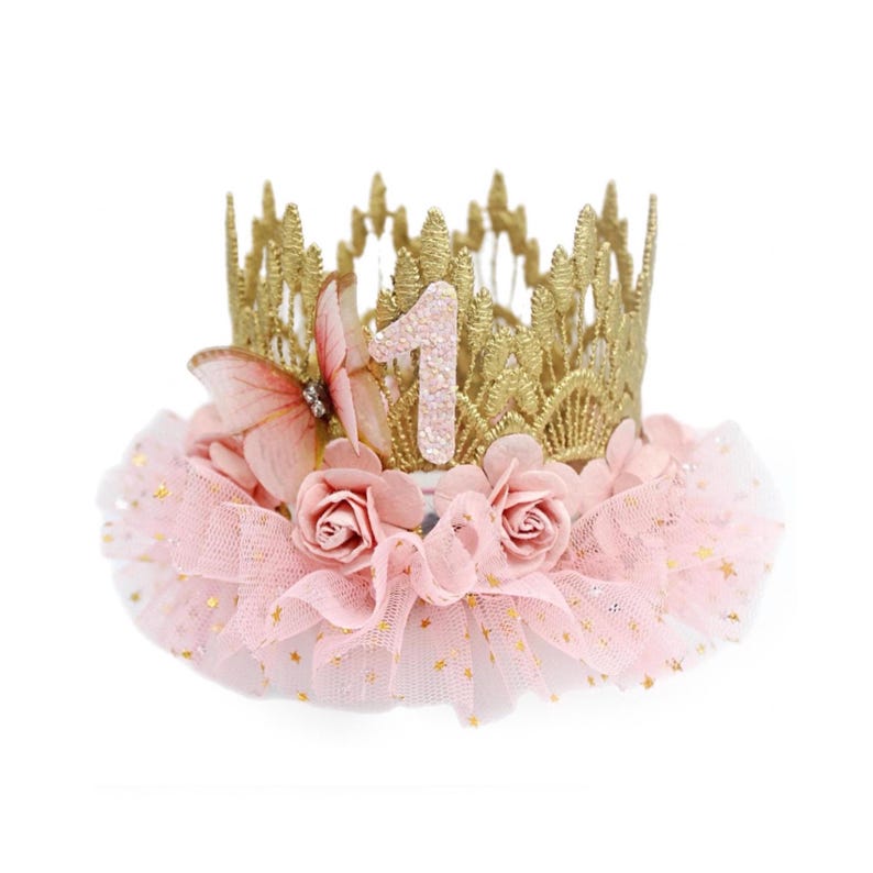 organza butterfly with rhinestone detail, blush pink roses, and blush pink ruffled tutu trim with gold stars. Perfect for baby girl first birthday, cake smash photoshoot, and fairy princess theme. Handmade by LoveCrush Crowns®. Can be customized in any age.