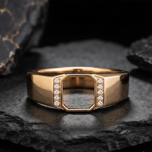 Könnte beinhalten: Ein goldener Ring mit einem achteckigen Ausschnitt in der Mitte, der von zwei vertikalen Reihen kleiner, klarer, rund geschliffener Steine eingerahmt wird. Die Ringschiene hat eine glatte, polierte Oberfläche und ein breites, flaches Profil.