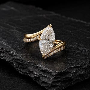 Op de afbeelding: Een gouden ring met een grote marquise-geslepen middensteen en twee banden in bypass-stijl, geaccentueerd met kleine ronde pavé-gezette steentjes. Het ontwerp bevat een gespleten ringband die de langwerpige middensteen omlijst.