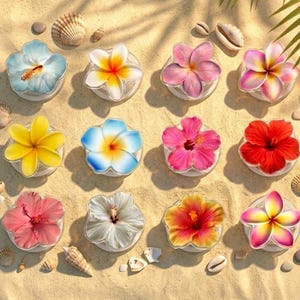 Puede incluir: Una vista cenital muestra una colección de soportes florales para teléfonos en varios colores, incluyendo azul, rosa, amarillo y rojo. Los soportes están dispuestos sobre una superficie arenosa, adornados con conchas marinas y pequeñas piedras, evocando un tema tropical.