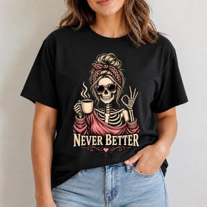 May include: A black t-shirt featuring a graphic of a skeleton with a messy bun, a leopard print headband, and sunglasses. The skeleton holds a steaming coffee mug and makes an okay hand gesture. The text NEVER BETTER is printed below in white.