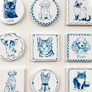 Grid of blue-and-white custom pet portrait magnets on a white background, featuring hand-drawn cats and dogs in round and square ceramic designs.