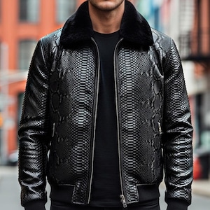 Könnte beinhalten: Schwarze Kunstlederjacke mit Schlangenmuster, schwarzem Pelzkragen und Reißverschluss. Die Jacke hat ein Design im Bomberstil mit gerippten Bündchen und Saum. Das Model trägt ein schwarzes T-Shirt und eine schwarze Jeans.