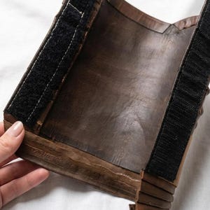 Puede incluir: Una taza de cer&aacute;mica blanca con un asa negra y el texto "But First, Coffee" en negrita negra. La taza se encuentra sobre un fondo borroso, sugiriendo un ambiente acogedor.