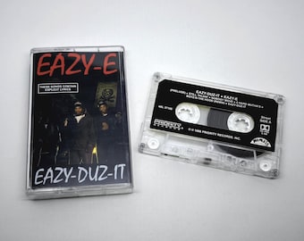 Könnte beinhalten: Zwei Vintage-Kassetten. Eine zeigt das Albumcover von Eazy-E's "Eazy-Duz-It" mit dem Namen des Künstlers in Rot und dem Albumtitel in Weiß. Die andere Kassette ist schwarz mit weißem Text, einschließlich Songtiteln und dem Priority Records-Logo.
