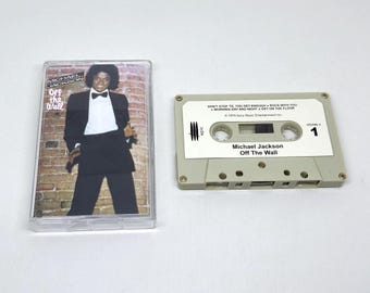 May include: A Michael Jackson Off The Wall cassette tape and its clear plastic case. The case insert shows Michael Jackson in a black tuxedo against a brick wall. The beige cassette tape features the Epic logo, track list, and album title.