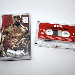 May include: Two clear cassette tapes. One has a cover with a photo of 50 Cent and the text "50 Cent Get Rich Or Die Tryin". The other cassette has a red label with the same text.
