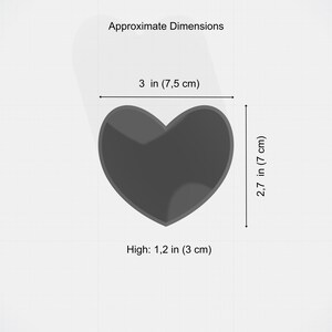 May include: A dark gray heart-shaped object with approximate dimensions of 3 inches (7.5 cm) wide, 2.7 inches (7 cm) high, and 1.2 inches (3 cm) thick. The image includes the text "Approximate Dimensions".