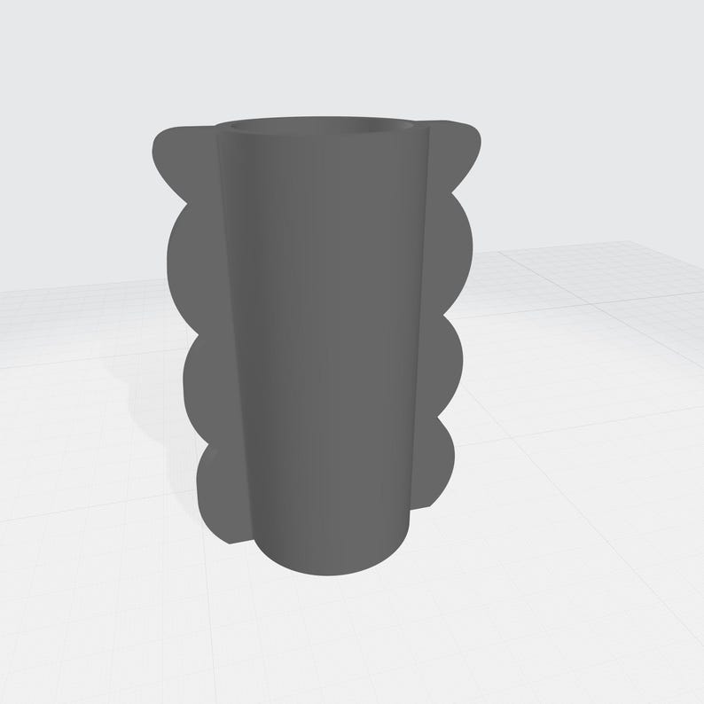May include: A gray, cylindrical vase with a scalloped edge design. The vase has a smooth, matte finish and a simple, modern aesthetic. The vase is suitable for holding flowers or other decorative items.