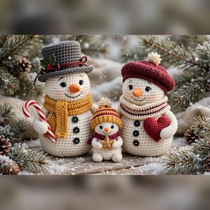 May include: Three crocheted snowmen figures. The largest wears a grey top hat with holly and a yellow scarf, holding a candy cane. The medium snowman wears a maroon beret and striped scarf, holding a red heart. The smallest wears a yellow hat.
