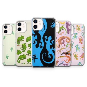 Puede incluir: Una colección de fundas para teléfonos con varios diseños de lagartos y geckos. Las fundas presentan una gama de colores, incluyendo verde, azul, morado y naranja. Algunas fundas tienen patrones repetidos, mientras que otras tienen ilustraciones únicas.