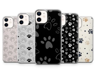 May include: A collection of five phone cases with paw print designs. The cases feature various color schemes, including black, gray, and cream, with paw prints in contrasting colors. The cases are designed to fit a smartphone.