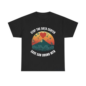 Op de afbeelding: Een zwart t-shirt met een grafische print van een berglandschap bij zonsondergang met een rood hart, vlinders en vogels. De tekst STOP THE DATA CENTER en SAVE SAN BRUNO MTN staat in witte hoofdletters in een cirkelvormig patroon.