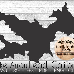 May include: Black and white silhouette of Lake Arrowhead, California, with a wood-grain circle logo that says "North Idaho Made" and "Small Local Family".