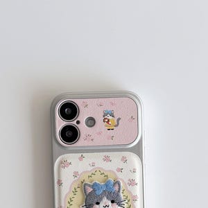 a smartphone with a pink and white floral case and a cat design on the back cover.