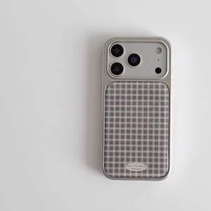 May include: A silver-colored phone case with a retro checkered pattern in shades of gray and white. The case has a metallic frame and a camera cutout. The text "Retro Checkered Pattern" is visible.