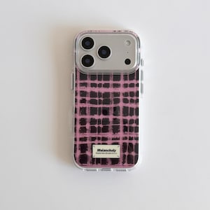 Könnte beinhalten: Transparente Handyhülle mit einem rosa-schwarzen Karomuster. Die Hülle hat ein silbernes Kameramodul mit drei Linsen. Der Text "Melancholy" befindet sich auf einem kleinen rechteckigen Etikett unten.