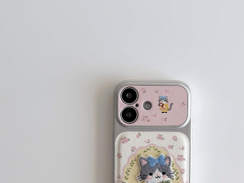 a smartphone with a pink and white floral design on the back cover and a cat image on the front cover.