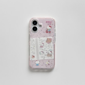 Pode incluir: Uma capa de telefone rosa com uma borda transparente e brilhante. A capa apresenta um design de caderno com ilustrações de Hello Kitty e texto japonês. O design inclui vários personagens Hello Kitty e outros elementos fofos.