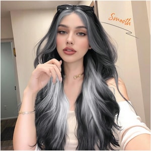May include: A person with long, wavy hair featuring a striking two-tone color scheme. The hair is primarily black and gray, with a bold white streak down the front. Sunglasses rest on top of the head. The word "Smooth" is written in orange.