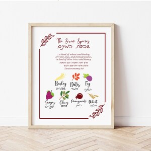 May include: A framed print featuring the text "The Seven Species" in English and Hebrew, with illustrations of barley, dates, figs, grapes, olives, pomegranates, and wheat. The print has a light wood frame and a white background.