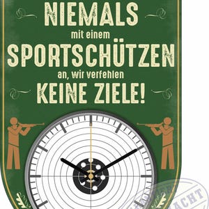 Puede incluir: Un letrero verde y dorado con el texto "LEG DICH NIEMALS mit einem SPORTSCHÜTZEN an, wir verfehlen KEINE ZIELE!" y una esfera de reloj con diana. El letrero también presenta ilustraciones de rifles y tiradores.