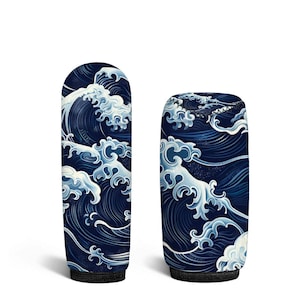 May include: Two cylindrical beverage insulators featuring a dark blue background with a repeating white and light blue stylized ocean wave pattern. The taller insulator has a rounded top, while the shorter one has a flat top with black stitching.