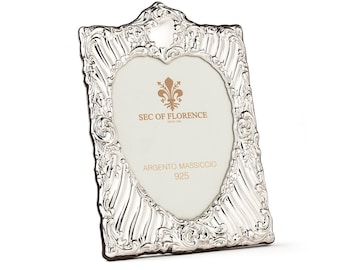 May include: A silver heart-shaped picture frame with ornate detailing. The frame has a silver fleur-de-lis design and the text "SEC OF FLORENCE" and "ARGENTO MASSICCIO 925".