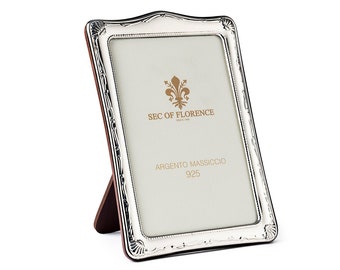 Puede incluir: Un marco de fotos de plata con un diseño ornamentado y un soporte de madera. El marco tiene el texto "SEC OF FLORENCE" y "ARGENTO MASSICCIO 925" en él.