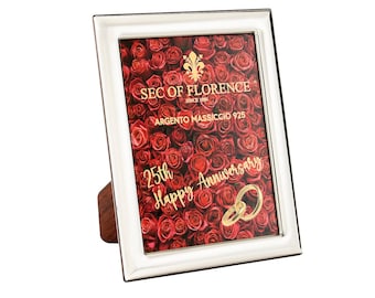 May include: A white silver-plated picture frame with a red rose background and gold lettering that reads "25th Happy Anniversary". The frame is made by Sec of Florence, since 1998, and is made of 925 sterling silver.