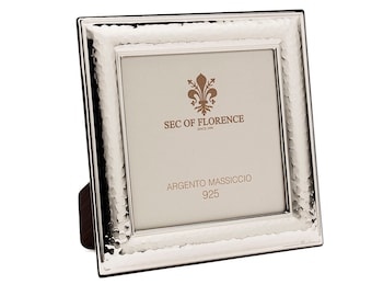 May include: A silver picture frame with a hammered finish. The frame has a small stand on the back and says "SEC OF FLORENCE" and "ARGENTO MASSICCIO 925" on the front.